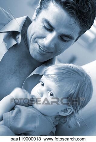 Stock Photo - Father looking at baby, close-up. Fotosearch