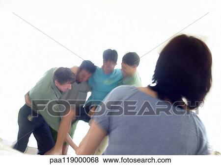 Stock Photo - Grandfather, father and boys standing in living room, playfighting, woman watching. Fotosearch