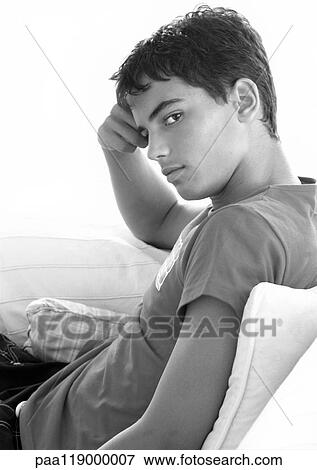 Teenage boy sitting, hand on head, b&w View Large Photo Image Stock Photo - Teenage boy sitting, hand on head, b&w. Fotosearch
