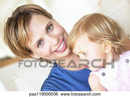 Stock Photograph - Woman holding baby, smiling. Fotosearch