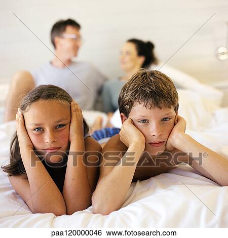 Children lying on parent's bed, looking at camera View Large Photo Image Stock Photograph - Children lying on parent's bed, looking at camera. Fotosearch