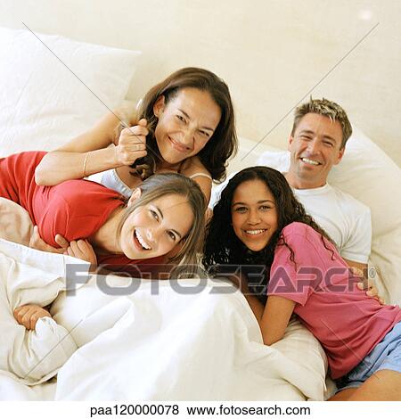 Family on bed, smiling View Large Photo Image Stock Photo - Family on bed, smiling. Fotosearch