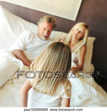 Girl talking to parents in bed, rear view View Large Photo Image Stock Photo - Girl talking to parents in bed, rear view. Fotosearch