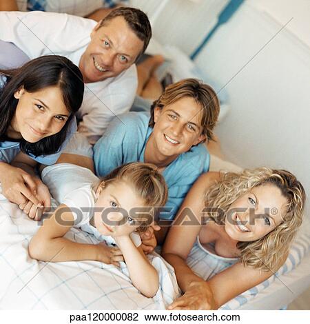 Parents and children lying on bed, smiling View Large Photo Image Stock Image - Parents and children lying on bed, smiling. Fotosearch