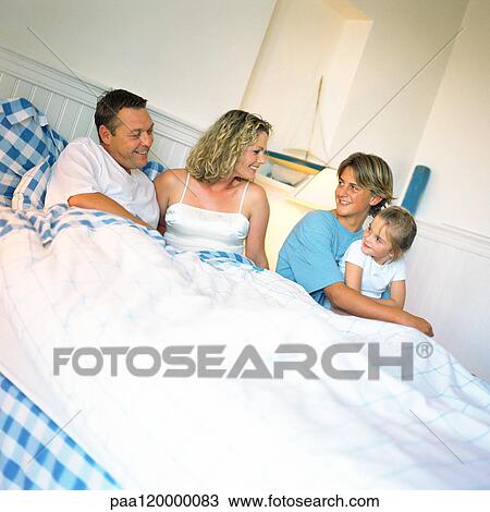 Parents and children on bed, smiling View Large Photo Image Stock Image - Parents and children on bed, smiling. Fotosearch