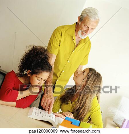 Senior man with two girls, pointing to book View Large Photo Image Stock Photo - Senior man with two girls, pointing to book. Fotosearch