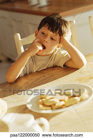 Boy sitting at table View Large Photo Image Stock Image - Boy sitting at table . Fotosearch