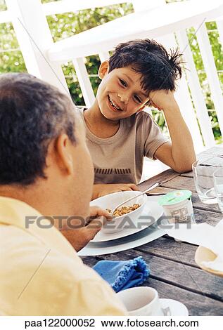 Father and son at table, close-up View Large Photo Image Stock Image - Father and son at table, close-up . Fotosearch