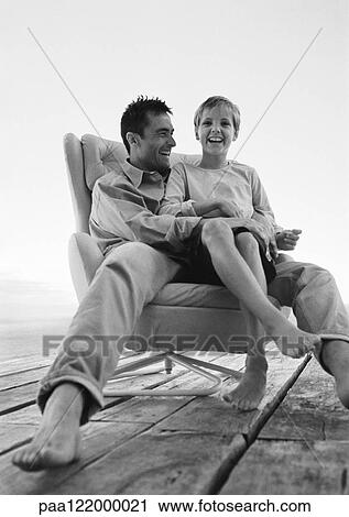 Father and son sitting in armchair, low angle view, b&w, portrait View Large Photo Image Stock Image - Father and son sitting in armchair, low angle view, b&w, portrait. Fotosearch