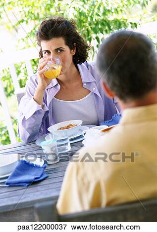 Man and woman having breakfast outside View Large Photo Image Stock Photo - Man and woman having breakfast outside. Fotosearch
