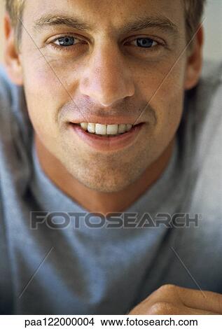 Picture - Man looking into camera, smiling, close-up, portrait. Fotosearch