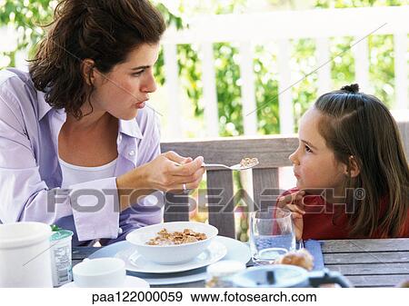 Mother and daughter having breakfast, close-up View Large Photo Image Stock Photo - Mother and daughter having breakfast, close-up. Fotosearch