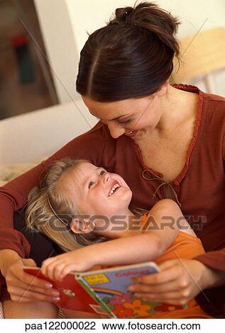Mother and daughter reading book, smiling View Large Photo Image Stock Image - Mother and daughter reading book, smiling. Fotosearch
