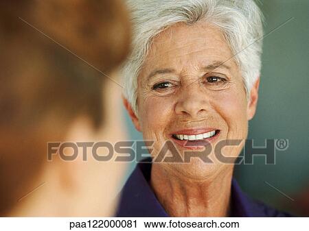 Senior woman looking at younger woman, close-up, blurred foreground View Large Photo Image Stock Image - Senior woman looking at younger woman, close-up, blurred foreground. Fotosearch