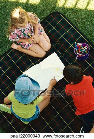 Three children kneeling on blanket outside, elevated view View Large Photo Image Stock Image - Three children kneeling on blanket outside, elevated view. Fotosearch