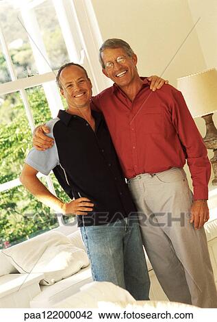 Two men standing side by side with arms around each other, smiling View Large Photo Image Stock Image - Two men standing side by side with arms around each other, smiling. Fotosearch