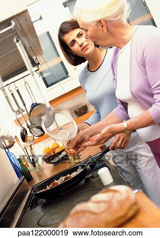 Two women cooking View Large Photo Image Stock Photo - Two women cooking. Fotosearch