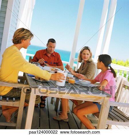 Couple and children having breakfast outside View Large Photo Image Stock Image - Couple and children having breakfast outside. Fotosearch