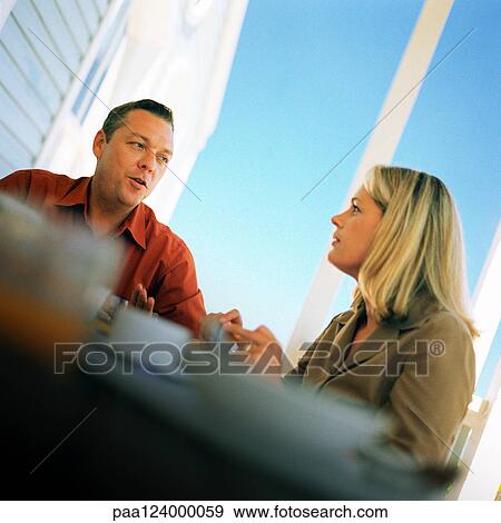 Couple at table, low angle view View Large Photo Image Stock Photo - Couple at table, low angle view. Fotosearch
