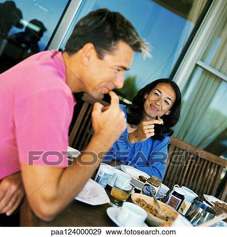 Couple having breakfast, smiling View Large Photo Image Stock Photo - Couple having breakfast, smiling. Fotosearch