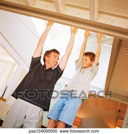 Father and son touching beam, smiling View Large Photo Image Stock Image - Father and son touching beam, smiling. Fotosearch