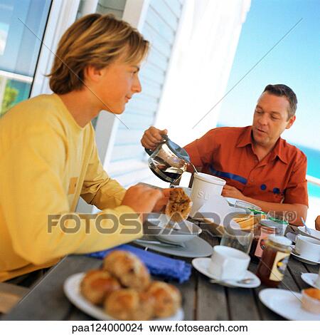 Man and teenage boy having breakfast outside View Large Photo Image Picture - Man and teenage boy having breakfast outside. Fotosearch