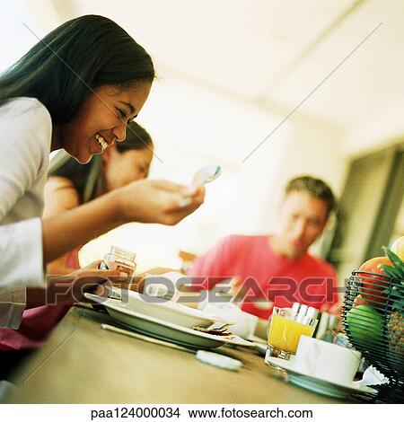 Man and two teenagers sitting at table, blurred View Large Photo Image Picture - Man and two teenagers sitting at table, blurred. Fotosearch