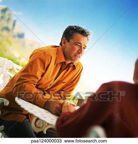 Man sitting at table outside View Large Photo Image Stock Image - Man sitting at table outside. Fotosearch