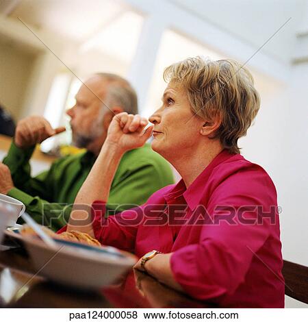 Stock Photo - Mature couple sitting at table, blurred. Fotosearch
