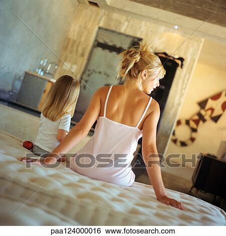 Mother and daughter sitting on bed, rear view View Large Photo Image Stock Photograph - Mother and daughter sitting on bed, rear view. Fotosearch