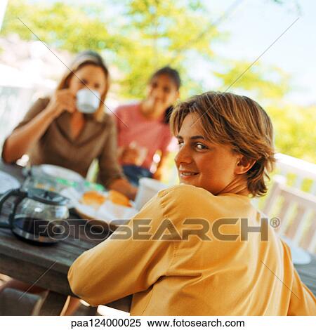 Teenage boy at table looking over shoulder, with family, portrait View Large Photo Image Stock Photography - Teenage boy at table looking over shoulder, with family, portrait. Fotosearch