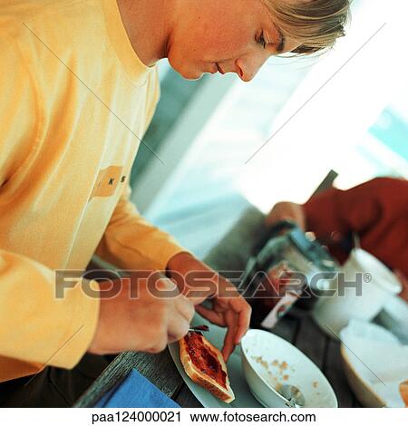 Teenage boy spreading jam on toast, close-up View Large Photo Image Stock Image - Teenage boy spreading jam on toast, close-up. Fotosearch