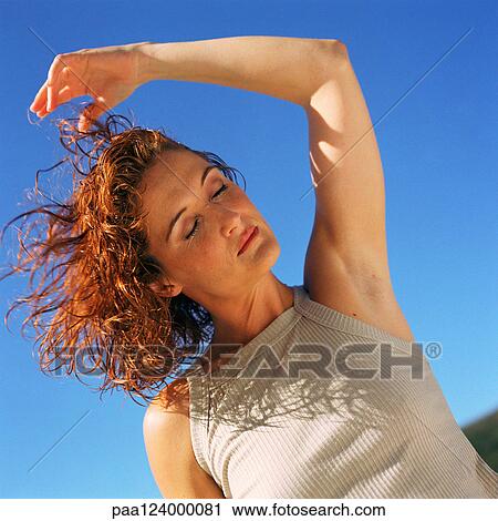 Woman with arm raised, eyes closed, low angle view, portrait View Large Photo Image Stock Image - Woman with arm raised, eyes closed, low angle view, portrait. Fotosearch