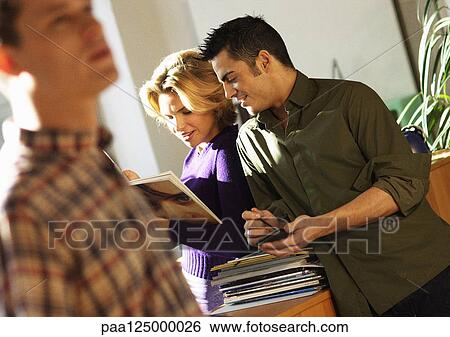 Co-workers interacting in office View Large Photo Image Stock Photograph - Co-workers interacting in office. Fotosearch