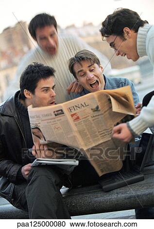 Stock Image - Four men looking at newspaper. Fotosearch