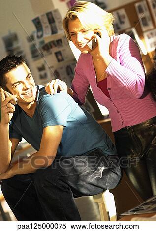 Man and woman using cell phones, smiling View Large Photo Image Stock Photography - Man and woman using cell phones, smiling. Fotosearch