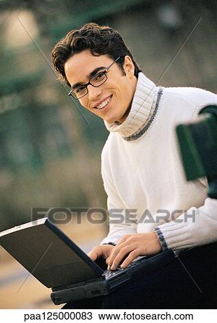 Man sitting on bench with laptop computer, portrait View Large Photo Image Stock Image - Man sitting on bench with laptop computer, portrait. Fotosearch