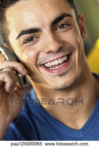 Man using cell phone, smiling, close-up View Large Photo Image Stock Photography - Man using cell phone, smiling, close-up. Fotosearch