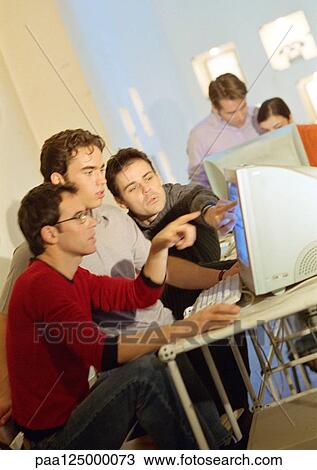 Stock Image - People working at computers in office, side view. Fotosearch