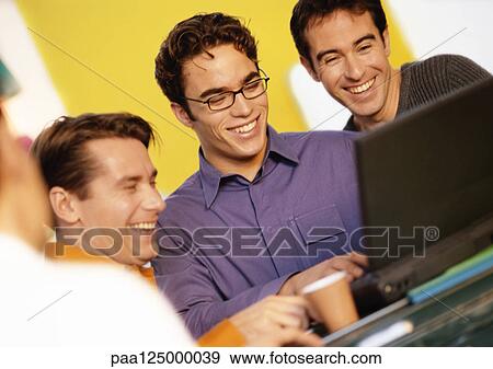 Three men looking at laptop computer View Large Photo Image Stock Photo - Three men looking at laptop computer. Fotosearch