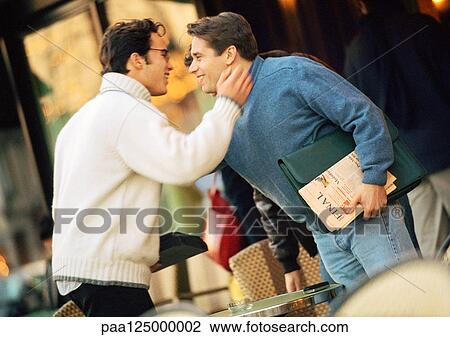 Two men at cafe terrace, smiling, side view View Large Photo Image Stock Image - Two men at cafe terrace, smiling, side view. Fotosearch