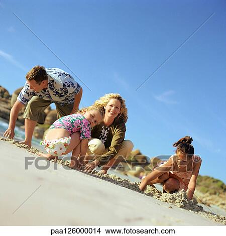 Couple and children digging in sand, portrait View Large Photo Image Picture - Couple and children digging in sand, portrait. Fotosearch
