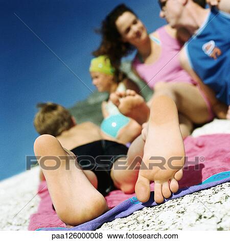 Couple and children lying on beach, focus on child's feet View Large Photo Image Stock Photo - Couple and children lying on beach, focus on child's feet. Fotosearch