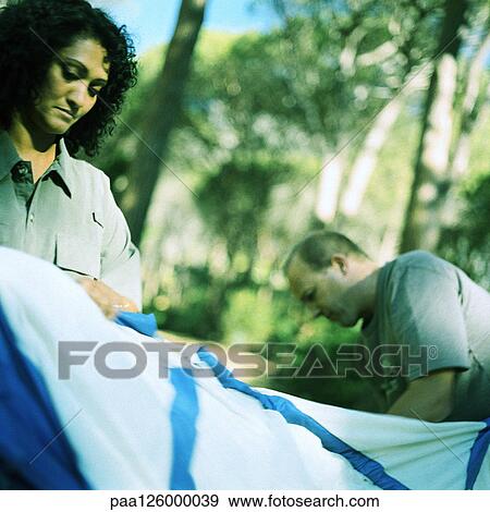 Couple setting up tent in woods View Large Photo Image Stock Photo - Couple setting up tent in woods. Fotosearch