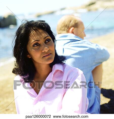 Couple sitting back to back on beach, focus on woman View Large Photo Image Stock Image - Couple sitting back to back on beach, focus on woman. Fotosearch