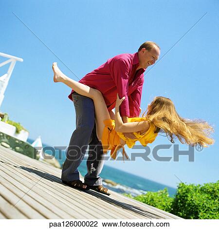 Stock Image - Father holding daughter, outside. Fotosearch