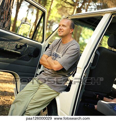 Man leaning against van with open doors View Large Photo Image Stock Photo - Man leaning against van with open doors. Fotosearch