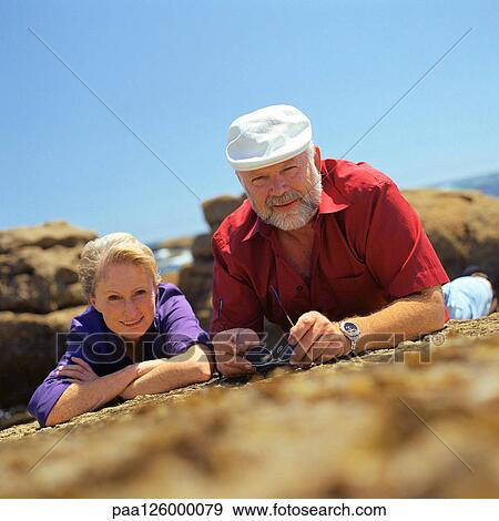 Mature couple lying on rock, surface level view View Large Photo Image Stock Photo - Mature couple lying on rock, surface level view. Fotosearch