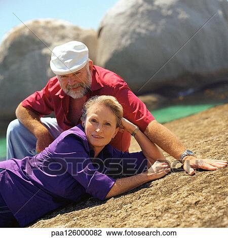 Mature couple resting on rock, portrait View Large Photo Image Stock Image - Mature couple resting on rock, portrait. Fotosearch