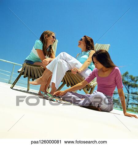 Stock Image - Mother and daughters sitting outside. Fotosearch